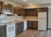 Thumbnail 26 of 54 - a kitchen with white appliances and dark wood cabinets