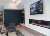 Thumbnail 52 of 54 - a living room with a tv and a table and chairs