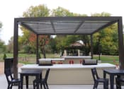 Thumbnail 50 of 54 - a patio with a bar and tables under awning
