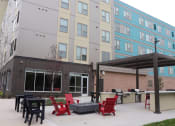Thumbnail 9 of 54 - a patio with red chairs and tables in front of a building