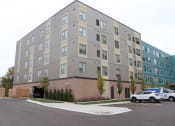 Thumbnail 46 of 54 - an apartment building with a police car parked in front of it