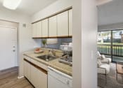 Thumbnail 5 of 7 - a kitchen with white cabinets and a sink and a window