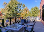 Thumbnail 27 of 29 - A patio with a table and chairs is surrounded by trees.