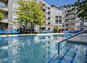 Thumbnail 1 of 29 - A large pool in front of apartment buildings.