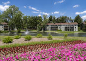 Thumbnail 2 of 36 - a view of a pond with flowers in front of a building