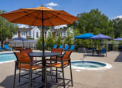 Thumbnail 10 of 17 - a table with chairs and an umbrella next to a pool