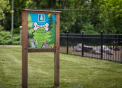 Thumbnail 26 of 36 - a sign in the middle of a grass field