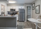 Thumbnail 2 of 20 - A modern kitchen with a refrigerator, microwave, oven, and sink.