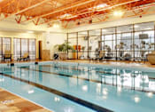 Thumbnail 10 of 13 - A large indoor swimming pool with a glass wall on one side.