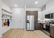Thumbnail 38 of 127 - A kitchen with a refrigerator, microwave, and oven.