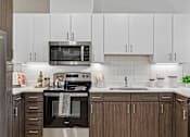Thumbnail 40 of 127 - A modern kitchen with a stainless steel oven and microwave.