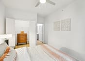 Thumbnail 18 of 140 - Bright bedroom with ceiling fan and wood flooring at Matador Apartments, Austin, TX