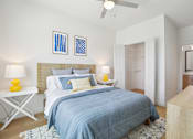 Thumbnail 63 of 116 - A bedroom with a bed, two lamps, and a ceiling fan. at Park South Apartments, Austin