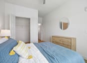 Thumbnail 64 of 116 - A bedroom with a bed, nightstand, and a mirror on the wall. at Park South Apartments, Austin, Texas