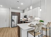 Thumbnail 45 of 127 - A kitchen with a white countertop and brown chairs.