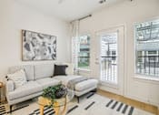 Thumbnail 5 of 140 - Bright living room with white sofa and patio access at Matador Apartments, Texas, 78745