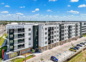 Thumbnail 28 of 127 - A large Augustine apartment complex with a parking lot in front.