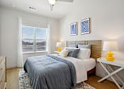 Thumbnail 66 of 116 - A bedroom with a bed, nightstand, and window. at Park South Apartments, Austin, TX
