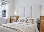 Thumbnail 47 of 127 - A bed with a white blanket and pillows in a room.