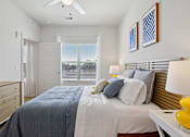 Thumbnail 67 of 116 - A bedroom with a bed, dresser, and ceiling fan. at Park South Apartments, Austin, TX, 78748