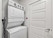 Thumbnail 51 of 127 - A white Whirlpool oven and dryer in a small, white-walled laundry room.