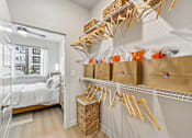 Thumbnail 52 of 127 - A room with a bed, a window, and a wall-mounted shelf with baskets and bags.