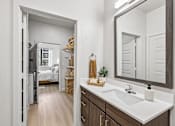 Thumbnail 54 of 127 - A bathroom with a white sink and a mirror.