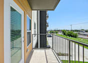 Thumbnail 74 of 116 - A balcony with a metal railing and a glass door leading to a patio. at Park South Apartments, Austin, TX, 78748