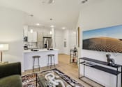 Thumbnail 104 of 140 - Open living room with kitchen island and bar stools at Matador Apartments, Austin