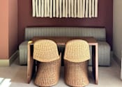Thumbnail 7 of 21 - Two chairs sit in front of a window with a curtain made of white circles.