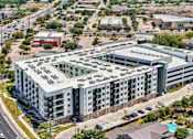 Thumbnail 57 of 127 - A large, modern building with a flat roof and a parking lot in front.