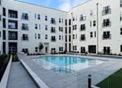 Thumbnail 50 of 83 - Resort-Style Pool area with building at ThreeTwenty at the Vybe Apartments, Kyle, 78640