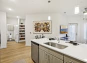 Thumbnail 109 of 140 - Kitchen island with stainless steel sink and pendant lighting at Matador Apartments, Austin, 78745