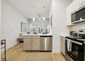 Thumbnail 7 of 140 - Open kitchen with island and dining area at Matador Apartments, Austin, TX 78745
