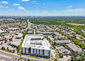 Thumbnail 66 of 127 - A large white building with a green roof is in the center of a busy intersection.