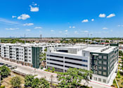 Thumbnail 67 of 127 - A large building complex with a parking garage in front.