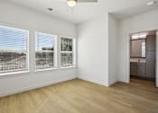 Thumbnail 126 of 140 - Empty bedroom with three windows and hardwood floors 1 at Matador Apartments, Austin, Texas