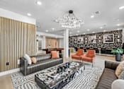 Thumbnail 74 of 127 - A living room with a black and white patterned rug, a black coffee table, and a chandelier.