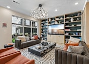 Thumbnail 77 of 127 - A modern living room with a large couch, a coffee table, and a bookshelf.