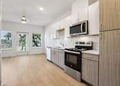 Thumbnail 124 of 140 - Open concept kitchen with wood tone cabinets at Matador Apartments, Austin