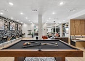 Thumbnail 84 of 127 - A pool table is in the middle of a room with a black and white striped rug.