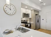 Thumbnail 51 of 116 - A modern kitchen with a clock on the wall. at Park South Apartments, Austin, TX