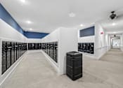 Thumbnail 86 of 127 - A long hallway with a black trash can in the middle.