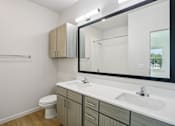Thumbnail 130 of 140 - Double sink bathroom with wood grain vanity at Matador Apartments, Austin