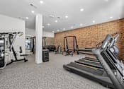 Thumbnail 87 of 127 - A gym with treadmills, weights, and other exercise equipment.