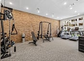 Thumbnail 88 of 127 - A gym with a variety of equipment including a treadmill, weights, and a bench press.