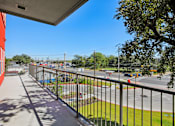 Thumbnail 140 of 140 - Balcony view of busy street and trees at Matador Apartments, Austin, Texas