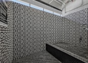 Thumbnail 93 of 127 - A black and white tiled room with a bench.