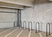 Thumbnail 97 of 127 - A parking garage with concrete walls and striped concrete floors.