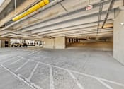 Thumbnail 99 of 127 - A large, empty parking garage with a yellow sign hanging from the ceiling.